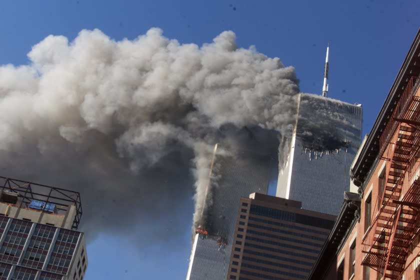 FILE - In this Sept. 11, 2001, file photo, smoke rises from the burning twin towers of the World Trade Center after hijacked planes crashed into the towers in New York City. Sept. 11 victims' relatives are greeting the news of President Donald Trump's now-canceled plan for secret talks with Afghanistan's Taliban insurgents with mixed feelings. (AP Photo/Richard Drew, File)