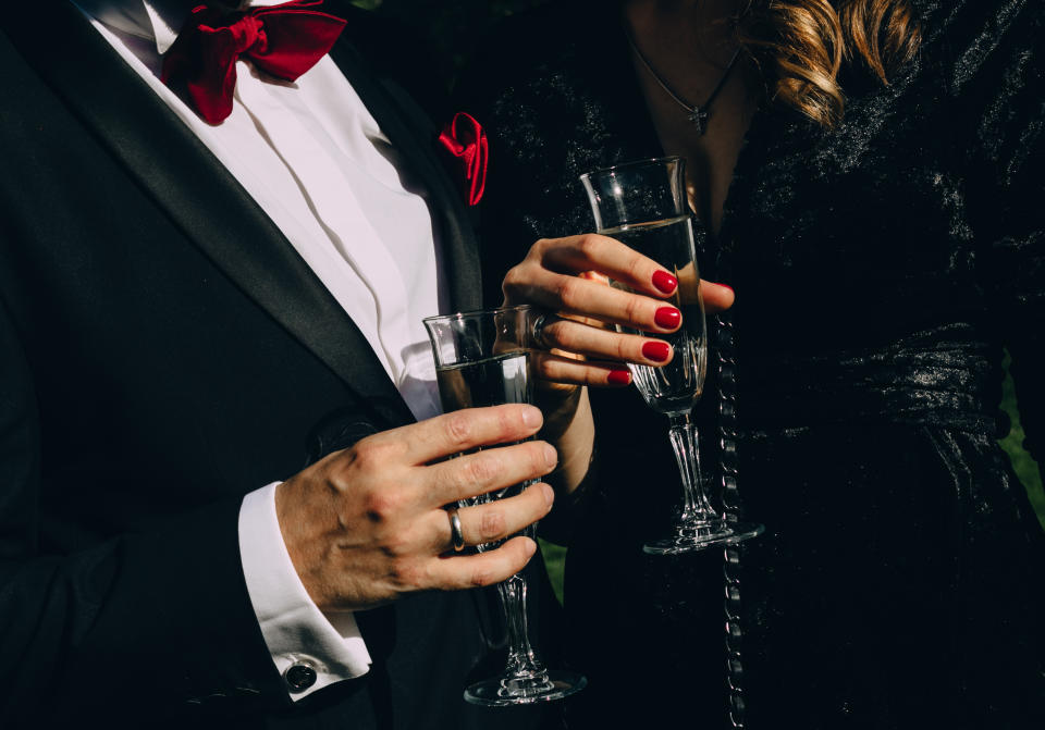 A man and a woman clink champagne glasses