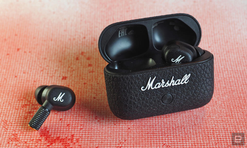 The Marshall Motif II ANC earbuds and charging case with a gridded red spray paint background.