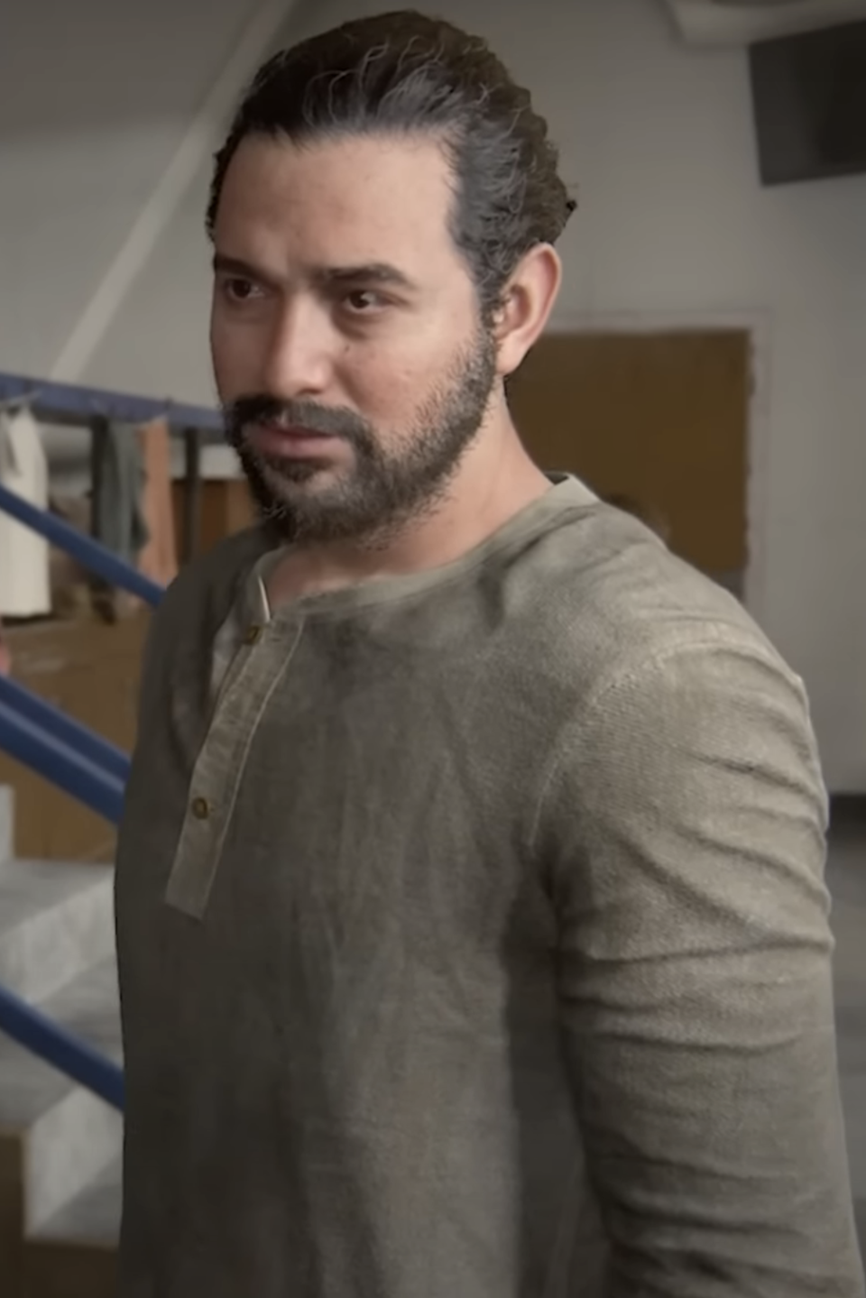 Manny in The Last of Us Part II in casual attire standing in a gym, looking to the side with a focused expression