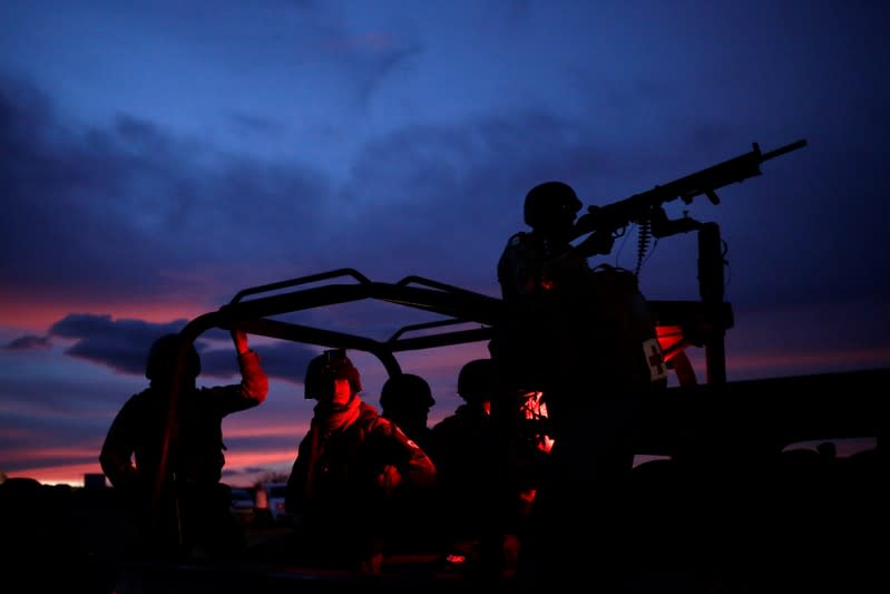 Miembros de la Guardia Nacional escoltan una caravana de vehículos con familiares y amigos que llegan a los funerales de una familia méxico-estadounidense de mormones asesinada en Bavispe, Sonora