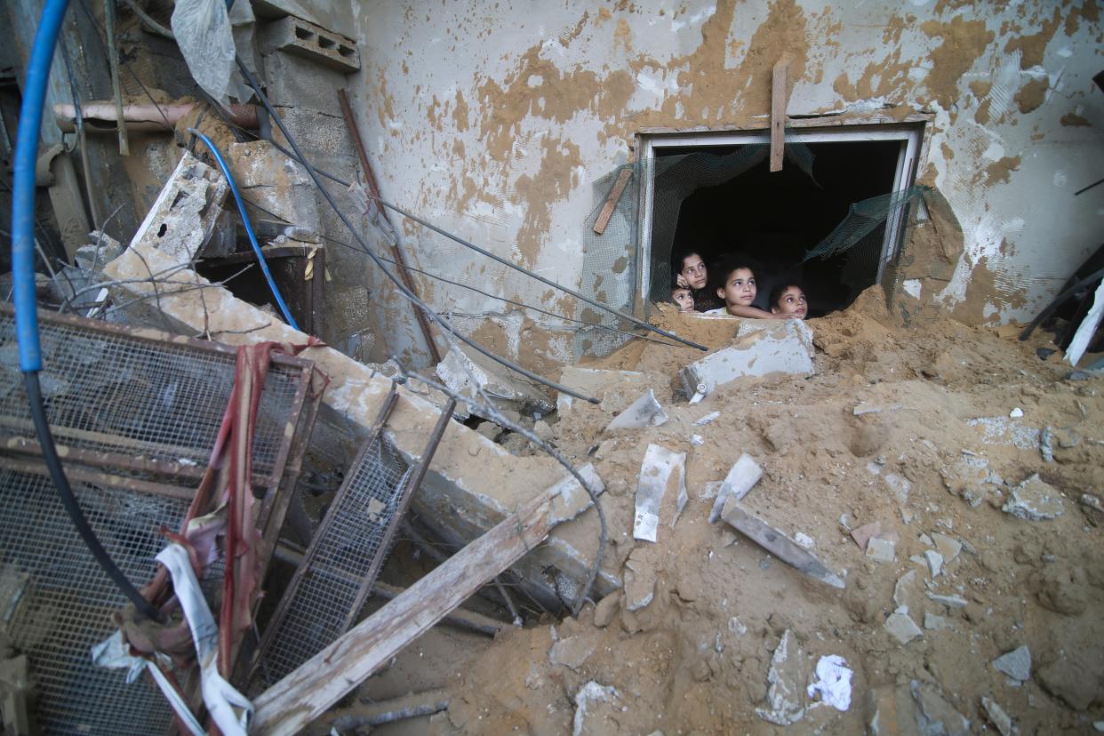 Palestinian children look at the building of the Zanon family, destroyed in Israeli airstrikes in Rafah (Copyright 2023 The Associated Press. All rights reserved.)