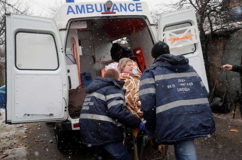 Medical specialists transport an injured woman to an ambulance following recent shelling in Donetsk.