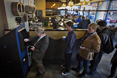 Customers line-up to use the world's first ever permanent bitcoin ATM unveiled at a coffee shop in Vancouver, British Columbia October 29, 2013. REUTERS/Andy Clark