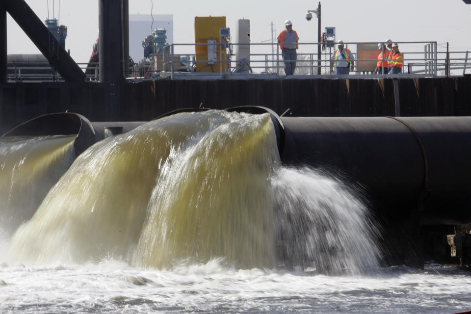 FILE - In this Saturday, March 10, 2007 file photo, Pumps put in place by the Army Corps of Engineers pump water from New Orleans' 17th Street Canal to Lake Pontchartra in New Orleans. New Orleans finds itself in the path of Hurricane Ida 16 years to the day after floodwalls collapsed and levees were overtopped by a storm surge driven by Hurricane Katrina. The federal government spent $14.5 billion on levees, pumps, seawalls, floodgates and drainage that provides enhanced protection from storm surge and flooding in New Orleans and surrounding suburbs south of Lake Pontchartrain. With the exception of three drainage projects, that work is complete (AP Photo/Bill Haber, File)