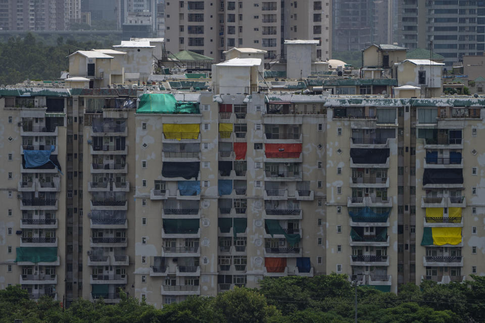 Balconies of nearby residential buildings are covered with plastic to block dust during controlled demolition of twin high-rise apartment towers in Noida, outskirts of New Delhi, India, Sunday, Aug. 28, 2022. The demolition was done after the country's top court declared them illegal for violating building norms. The 32-story and 29-story towers, constructed by a private builder were yet to be occupied and became India's tallest structures to be razed to the ground. (AP Photo/Altaf Qadri)