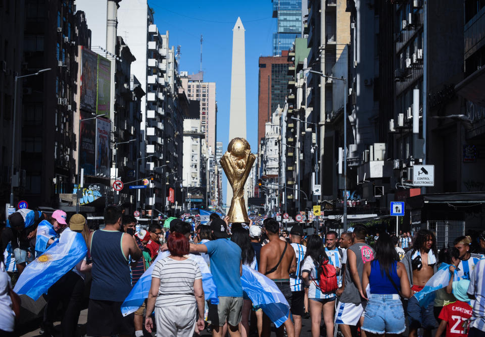 Soccer Football - FIFA World Cup Qatar 2022 - Argentina Victory Parade after winning the World Cup - Buenos Aires, Argentina - December 20, 2022  General view of Argentina fans at the Obelisco holding a World Cup trophy replica after the the victory parade was cancelled and Argentina players departed REUTERS/Mariana Nedelcu