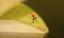 A golfer fishes his ball out of the water under a train bridge. After 67 years in the Liberty Village location, The Model Railroad Club of Toronto will be moving to make way for a condo.