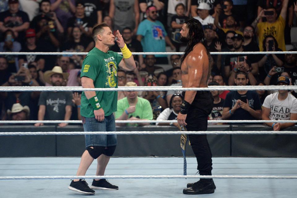 John Cena (left) returned to WWE to confront Universal champ Roman Reigns at the "Money in the Bank" event.
