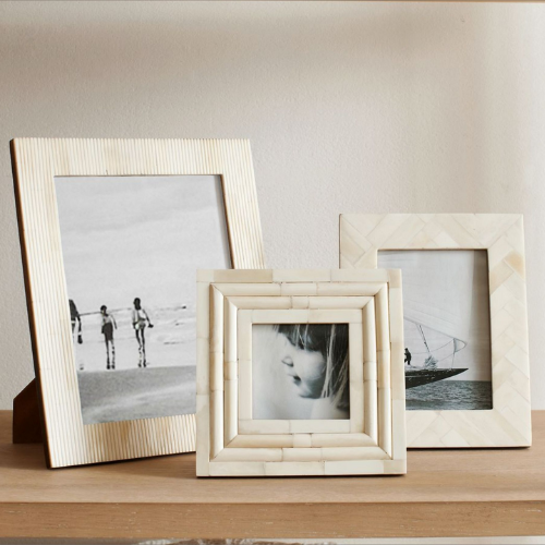 3 light beige picture frames sitting on table