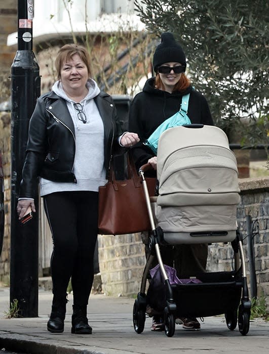 Stacey Dooley pushing her babys pram alongside her mother