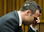 Oscar Pistorius, puts his hand to his face while listening to cross questioning about the events surrounding the shooting death of his girlfriend Reeva Steenkamp, during his trial in Pretoria, South Africa, Friday, March 7, 2014. Pistorius is charged with murder for the shooting death of Steenkamp, on Valentines Day in 2013. (AP Photo/Theana Breugem, Pool)