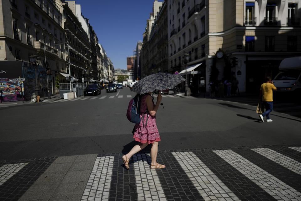 FILE - A woman holds an umbrella to protect herself from the sun, in Paris, Sept. 6, 2023. After a summer of record-smashing heat, warming somehow got even worse in September as Earth set a new mark for how far above normal temperatures were, the European climate agency reported Thursday, Oct. 5.(AP Photo/Thibault Camus, File)