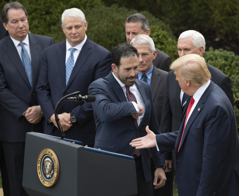 Bruce Greenstein of LHC Group offers an elbow bump as President Trump reaches for a handshake. (Jim Watson/AFP via Getty Images)