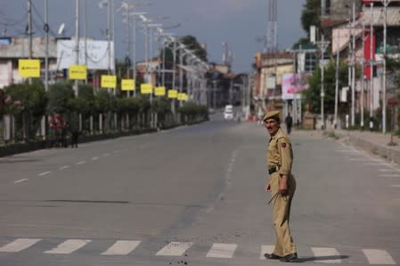 An Indian police officer crosses an empty road during restrictions on Eid-al-Adha after the scrapping of the special constitutional status for Kashmir by the Indian government, in Srinagar