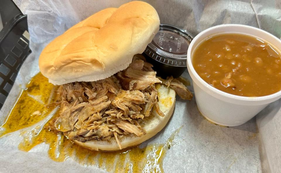 Pulled pork sandwich with a side of Nashville hot sauce and Buffalo Trace bourbon bacon baked beans from The Blazing Pig in Jackson Township.