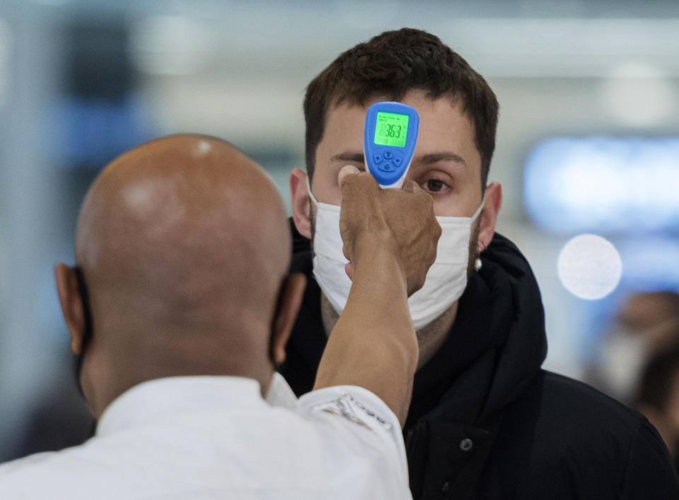 A man has his temperature checked prior to entering a store in Montreal, Sunday, Nov. 22, 2020, as the COVID-19 pandemic continues in Canada and around the world. (Graham Hughes/The Canadian Press via AP)