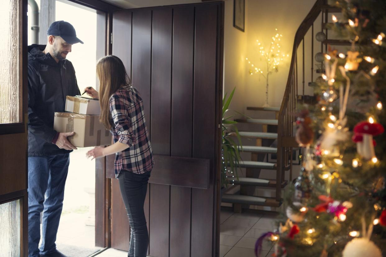 Teenager receiving Christmas packages delivered by postman