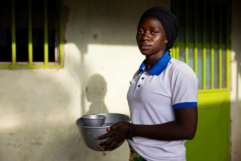 Béatrice Naguita, de 22 años, que fue secuestrada junto a su hermano en 2023, porta un balde de agua el 15 de junio de 2024 en Pala, Chad (Joris Bolomey)