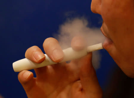 FILE PHOTO: A man smokes iQOS at a restaurant in Tokyo, Japan November 2, 2017. REUTERS/Kim Kyung-Hoon/File Photo