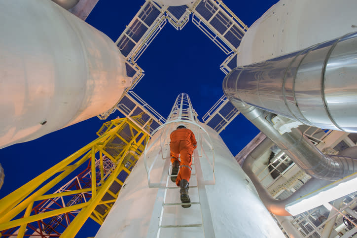 An engineer climbing to the top of storage infrastructure for inspection.