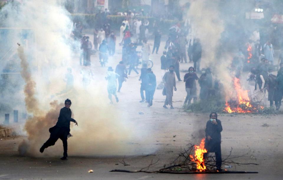 Pakistan Tehreek-e-Insaf (PTI) supporters clash with police on Friday (EPA)