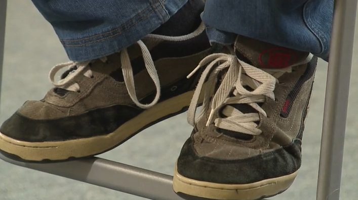 A pair of old Vans sneakers on feet