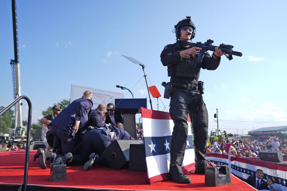 Former President Donald Trump is covered by Secret Service agents after shots were fired (Evan Vucci / AP)