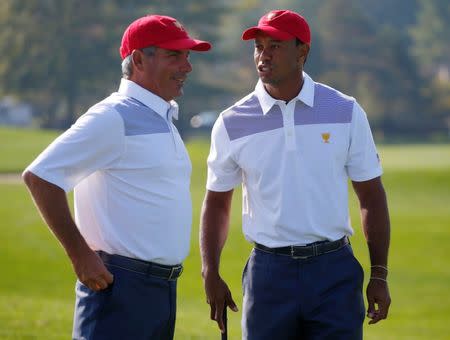 FILE PHOTO: U.S. golfer Tiger Woods talks with team captain Fred Couples (L) during the first practice round for the 2013 Presidents Cup golf tournament at Muirfield Village Golf Club in Dublin, Ohio October 1, 2013. REUTERS/Jeff Haynes