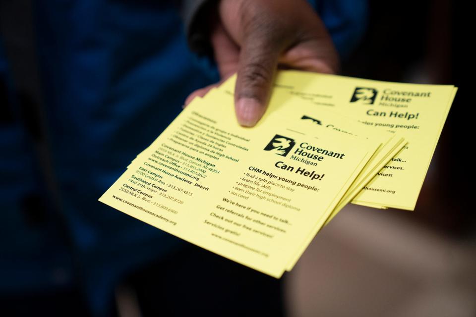 Stephanie Taylor, 50, outreach manager at Covenant House Michigan, shows the cards she and her teammates hand out in hopes of leading vulnerable and homeless youths to their facility as they do street outreach in Detroit on Dec. 9, 2022.