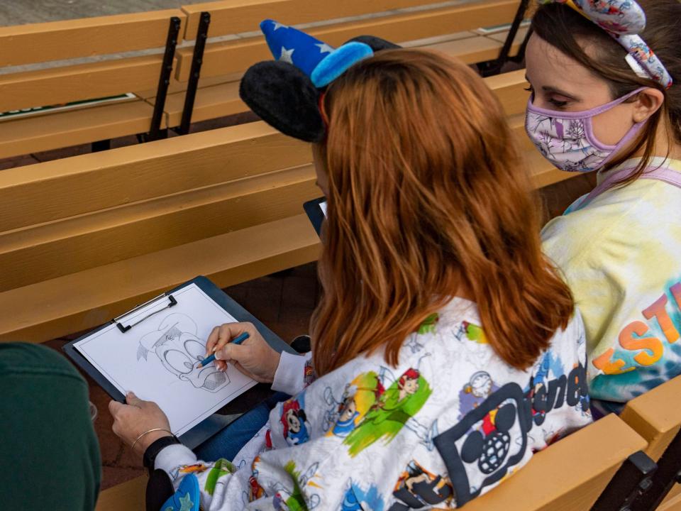 two disney guests drawing characters during the animation experience