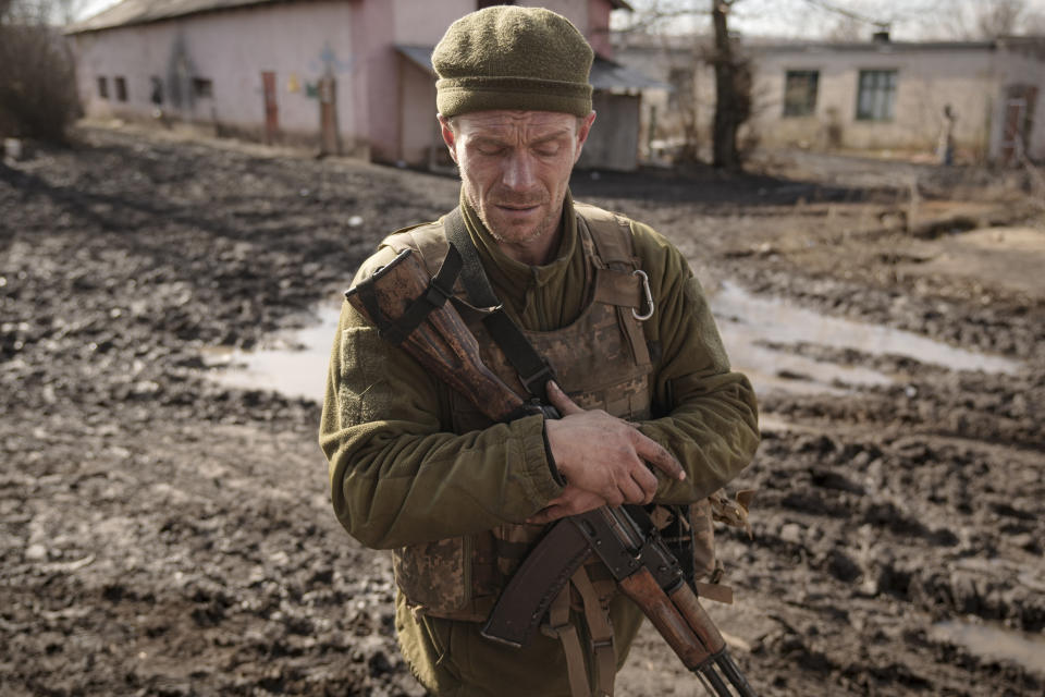 A Ukrainian serviceman walks near the frontline village of Krymske, Luhansk region, in eastern Ukraine, Saturday, Feb. 19, 2022. Ukrainian President Volodymyr Zelenskyy, facing a sharp spike in violence in and around territory held by Russia-backed rebels and increasingly dire warnings that Russia plans to invade, on Saturday called for Russian President Vladimir Putin to meet him and seek resolution to the crisis. (AP Photo/Vadim Ghirda)