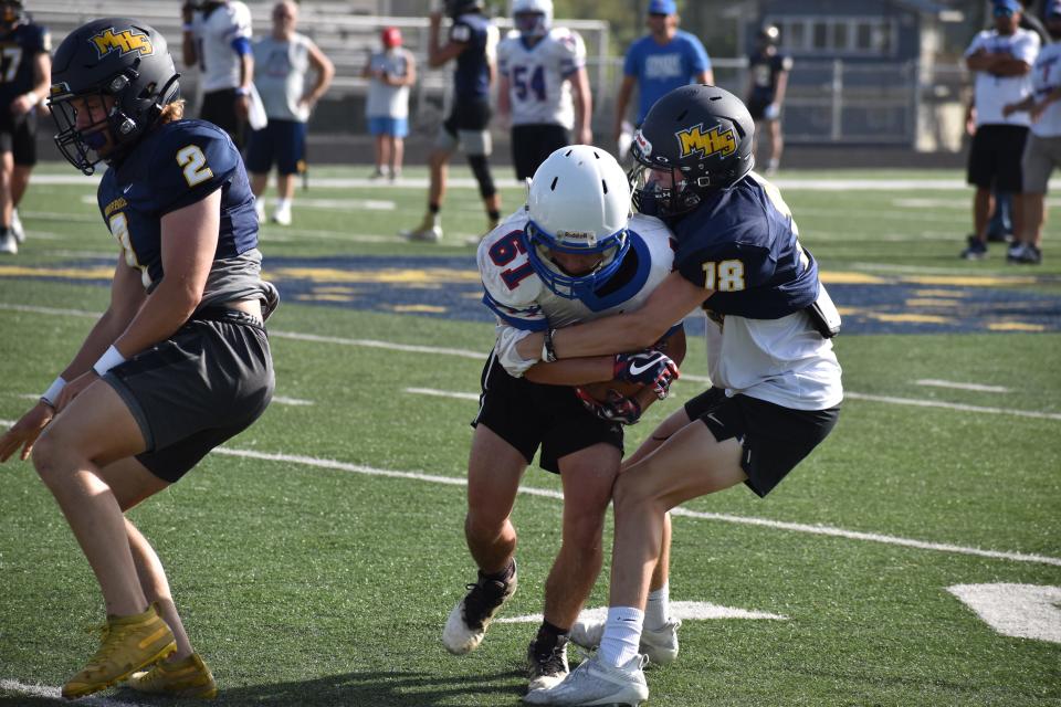 Mooresville's JJ Knight brings down an Indian Creek player during the Pioneers' scrimmage with the Braves on June 15, 2022.