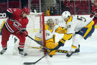 Nashville Predators goaltender Juuse Saros (74) and defenseman Roman Josi (59) defend against Carolina Hurricanes left wing Warren Foegele (13) during the second period of an NHL hockey game in Raleigh, N.C., Saturday, April 17, 2021. (AP Photo/Gerry Broome)