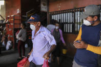 Pasajeros, con tapabocas para protegerse del nuevo coronavirus, se alistan para subir a un bus en el mercado de Mayoreo en Managua, Nicaragua, el 7 de abril de 2020. Los restaurantes están vacíos, hay poco tráfico en las calles y los bañistas escasean pese a ser Semana Santa aunque el gobierno pidió a los nicaragüenses que sigan con su vida pese a la pandemia de coronavirus. (AP Foto/Alfredo Zúñiga)