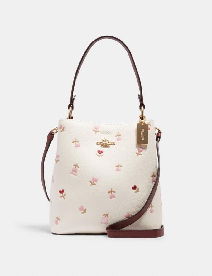 Bolso Bucket pequeño con estampado floral de corazones (imagen a través de Coach Outlet).