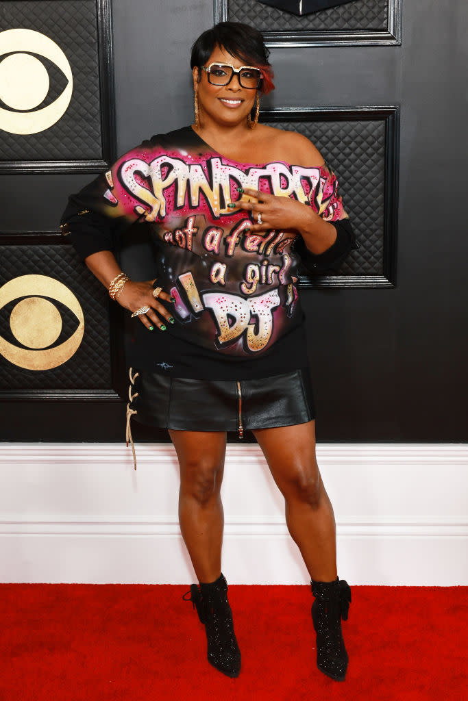 DJ Spinderella in short black leather skirt and top printed with her name saying: not a fella a girl 'DJ.'