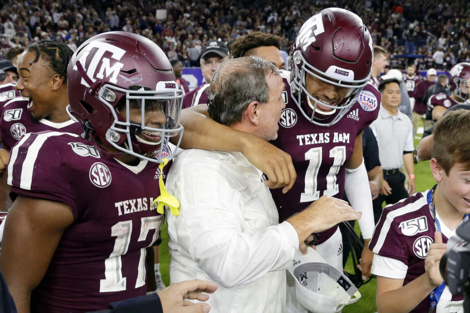 Texas A&M wide receiver Ainias Smith (17), coach Jimbo Fisher and quarterback Kellen Mond (11) celebrate after the team's 24-21 win against Oklahoma State in the Texas Bowl NCAA college football game Friday, Dec. 27, 2019, in Houston. (AP Photo/Michael Wyke)