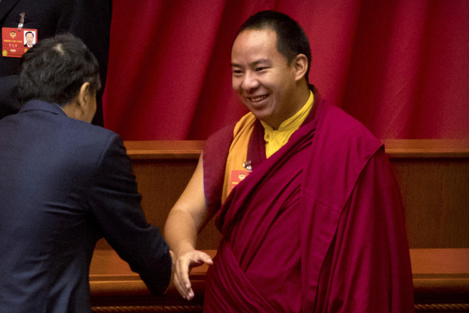 FILE - In this March 15, 2018, file photo, Gyaltsen Norbu, the Chinese government-appointed 11th Panchen Lama, shakes hands with a fellow delegate before the closing session of the Chinese People's Political Consultative Conference (CPPCC) at the Great Hall of the People in Beijing. Tibet’s self-declared government-in-exile marked the 25th anniversary of the disappearance of a boy named as Tibetan Buddhism’s second highest figure by calling on China on Sunday, May 17, 2020 to account for his whereabouts. China, which claims Tibet as its own territory, named another boy, Gyaltsen Norbu, to the position and he is believed to live under close government control in mainland China and is rarely seen in public. (AP Photo/Mark Schiefelbein, File)