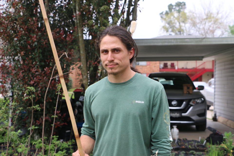 Louisiana farmer Bruno Sagrera shows off a blow gun he made out of river cane