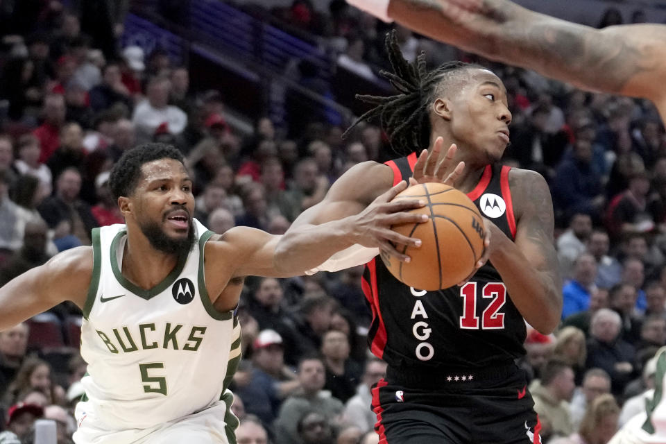 Chicago Bulls' Ayo Dosunmu (12) looks to pass under pressure by Milwaukee Bucks' Malik Beasley during the first half of an NBA basketball game, Thursday, Nov. 30, 2023, in Chicago. (AP Photo/Charles Rex Arbogast)