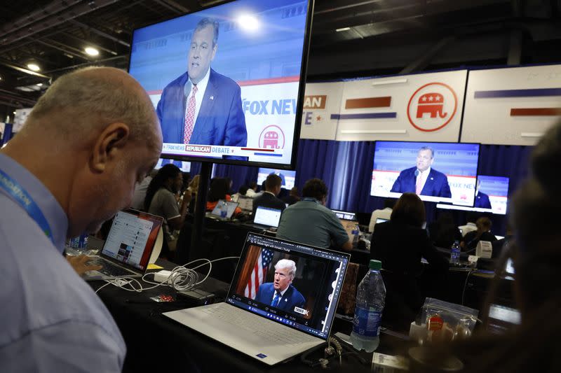 Un reportero observa la entrevista en línea del expresidente Donald Trump con Tucker Carlson en el centro de medios durante el primer debate de candidatos republicanos de la campaña presidencial estadounidense de 2024 en Milwaukee, Wisconsin, Estados Unidos