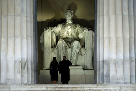 President-elect Donald Trump salutes the statue of Abraham Lincoln as he and his wife Melania take part in a Make America Great Again welcome concert in Washington. REUTERS/Jonathan Ernst