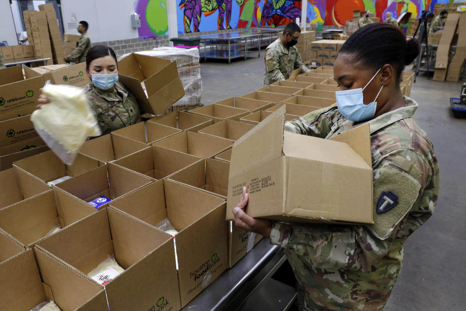 Texas National Guard soldiers Spc. Esmeralda Zuniga, left, and Spc. Samantha McClasky, right, load boxes with various dairy products such as milk, cheese and butter, at the Houston Food Bank Wednesday, Oct. 14, 2020, in Houston. When the pandemic hit last March, the volunteer count at the food bank dropped 80 percent. The Guard stepped in to fill the gap and has been assisting ever since. (AP Photo/Michael Wyke)