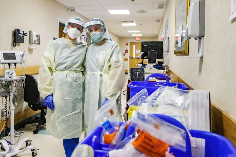 Sally Fowler, 21, and her best friend Emily Brown, 23, who are both nurses working in the yellow level COVID unit at Tallahassee Memorial HealthCare, pose for a photo in the hallway of the unit, which is lined with medical supplies and computers Monday, Aug. 23, 2021.