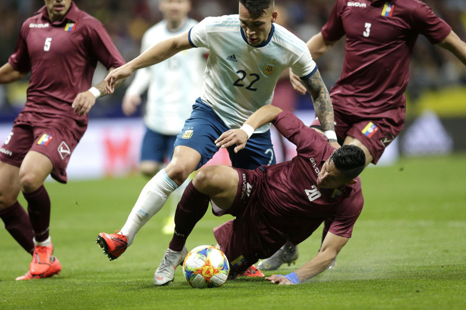 Venezuela's Ronald Hernandez, on the ground, fights for the ball with Argentina's Lautaro Martinez during an international friendly soccer match between Argentina and Venezuela at Wanda Metropolitano stadium in Madrid, Spain, Friday, March 22, 2019. (AP Photo/Bernat Armangue)