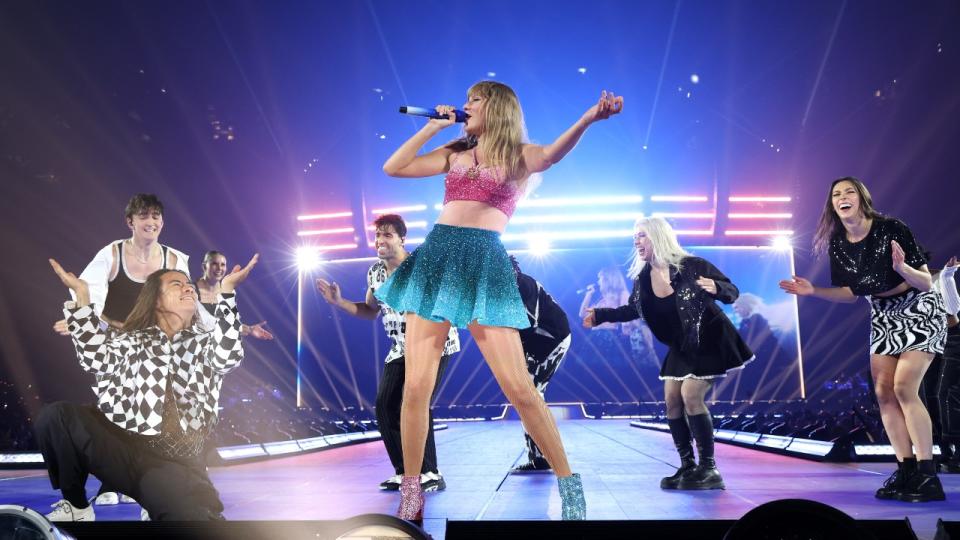 Taylor Swift in her pink and blue 1989 outfit with her dancers behind her during her first show of the Eras Tour on May 9 in Paris, France.