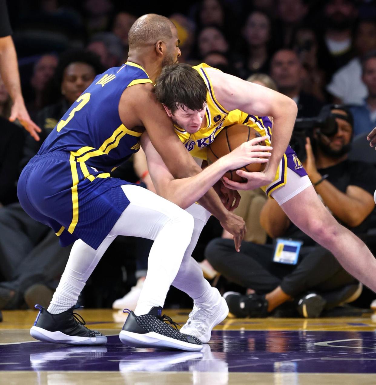 Lakers guard Austin Reaves, right, and Warriors guard Chris Paul battle for control of the ball Tuesday night.