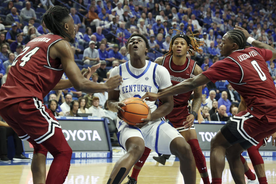 Kentucky's Adou Thiero, center front, looks for an opening between New Mexico State's Jonathan Kanyanga (24) and Jaylin Jackson-Posey (0) during the first half of an NCAA college basketball game in Lexington, Ky., Monday, Nov. 6, 2023. (AP Photo/James Crisp)