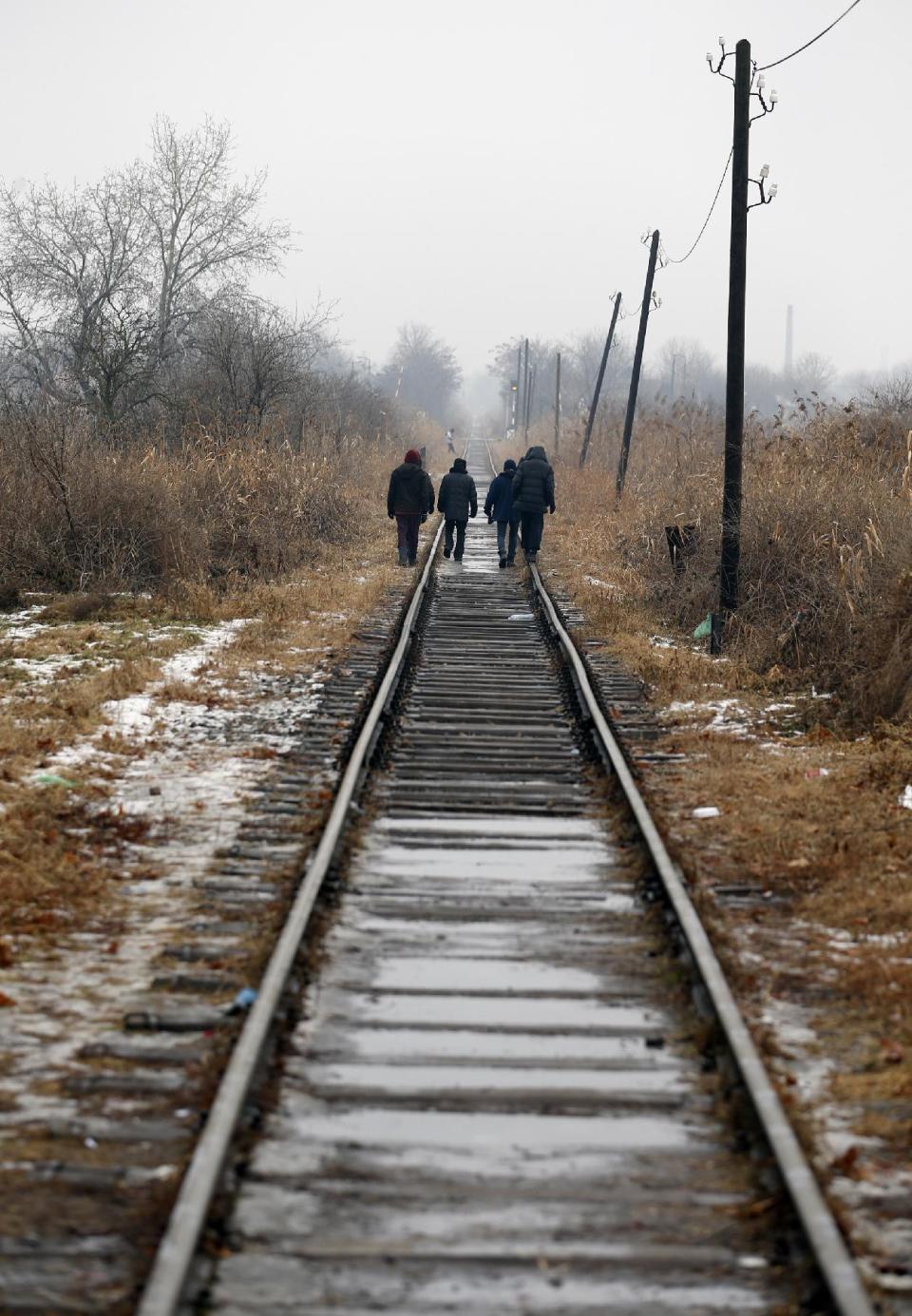 Migrants walk on train tracks close to the northern Serbian town of Subotica, near the border between Serbia and Hungary, Wednesday, Feb. 1, 2017. Thousands of migrants have been stranded in Serbia and looking for ways to cross illegally into the European Union. (AP Photo/Darko Vojinovic)